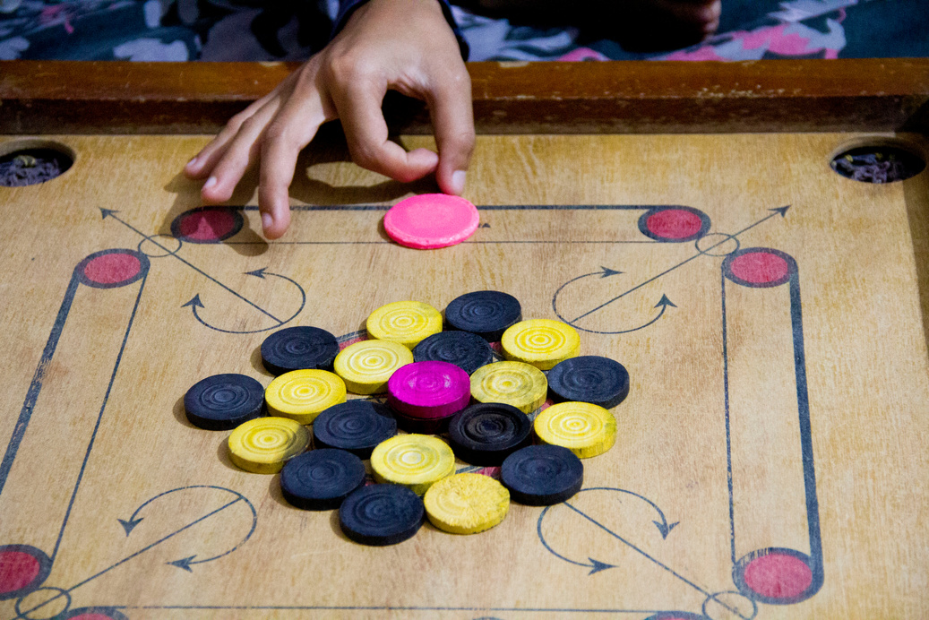 A game of carrom with pieces carrom man on the board carrom. Carom board game, selective focus.